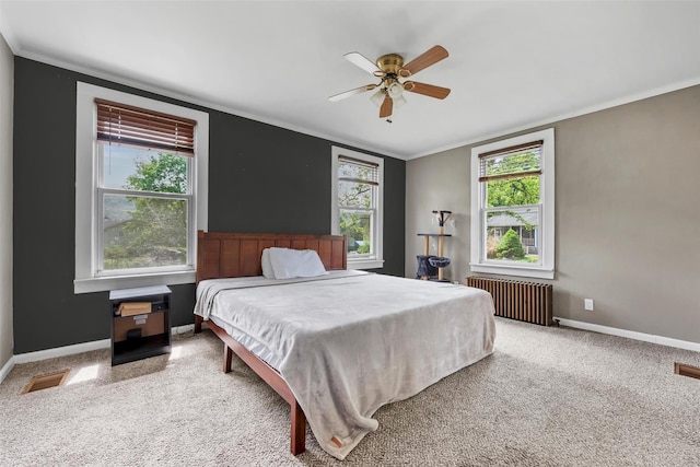 carpeted bedroom with visible vents, ornamental molding, radiator, baseboards, and ceiling fan