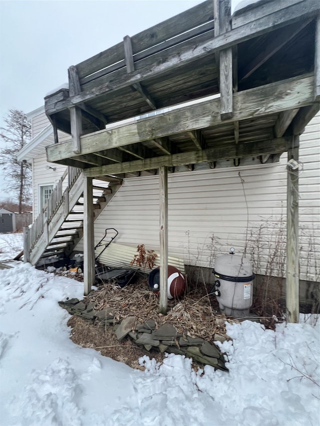 snow covered property featuring stairway