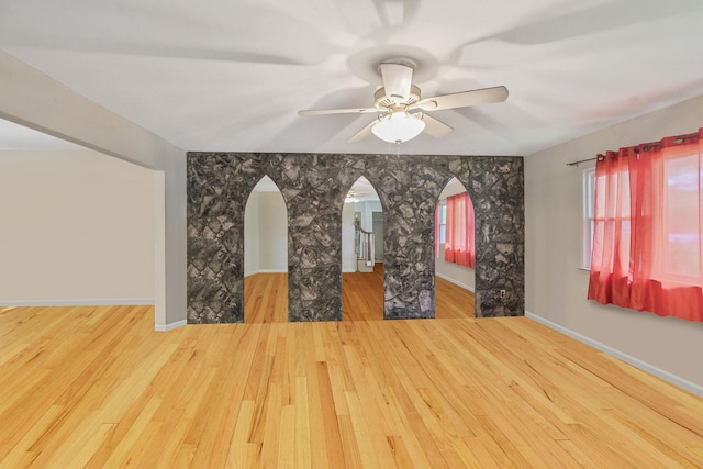 25 Adrienne Ln, Hauppauge, NY 11788 - unfurnished living room with arched walkways, ceiling fan, and wood finished floors