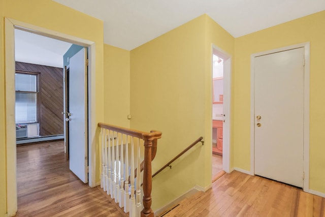 25 Adrienne Ln, Hauppauge, NY 11788 - hall with a baseboard heating unit, baseboards, an upstairs landing, and wood finished floors
