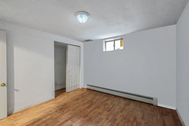25 Adrienne Ln, Hauppauge, NY 11788 - below grade area with a textured ceiling, baseboards, wood finished floors, and baseboard heating