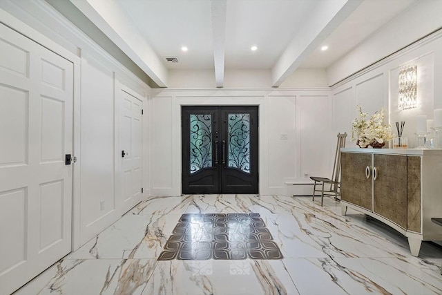 entryway with french doors, a decorative wall, marble finish floor, and visible vents