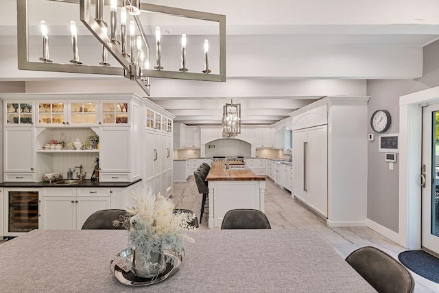 dining space featuring beverage cooler, baseboards, and a chandelier