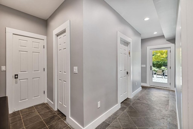 foyer entrance with baseboards and recessed lighting