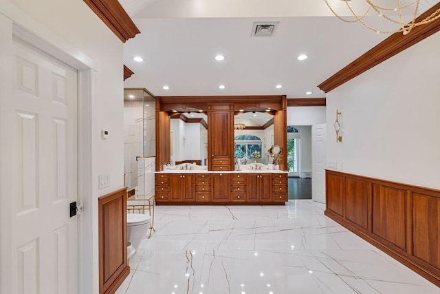 bathroom with double vanity, visible vents, crown molding, wainscoting, and marble finish floor