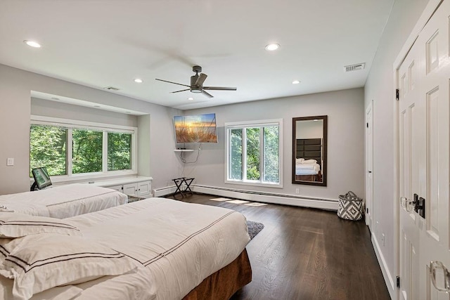 bedroom featuring visible vents, a baseboard radiator, dark wood-type flooring, and multiple windows