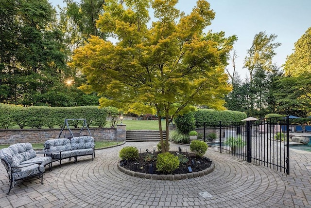 view of community with fence, a patio, and an outdoor living space