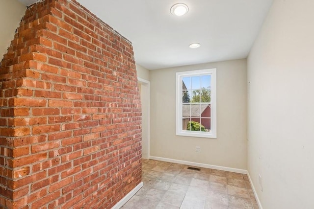 645 Hamilton Ave, Mattituck, NY 11952 - empty room with baseboards, recessed lighting, and brick wall