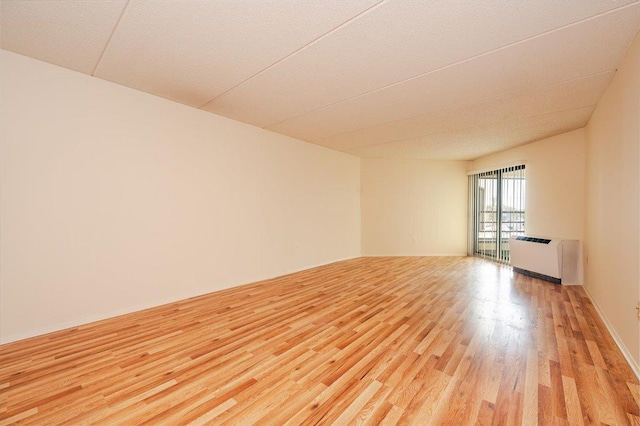 empty room with light wood finished floors and radiator