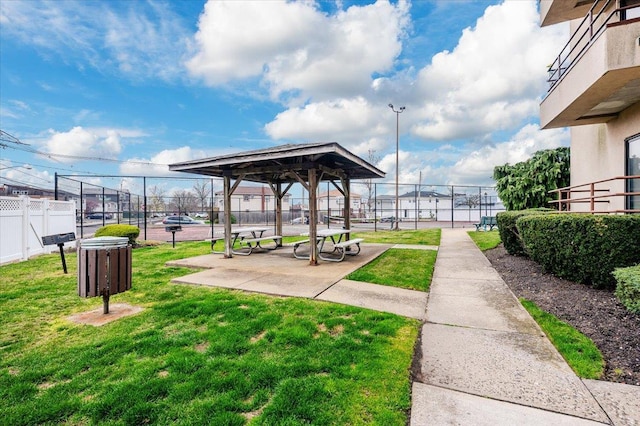 view of community with a yard and fence