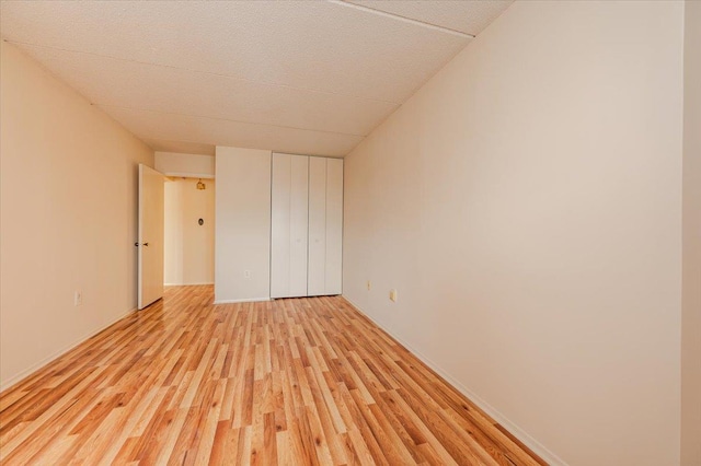 unfurnished bedroom with a closet and light wood-type flooring