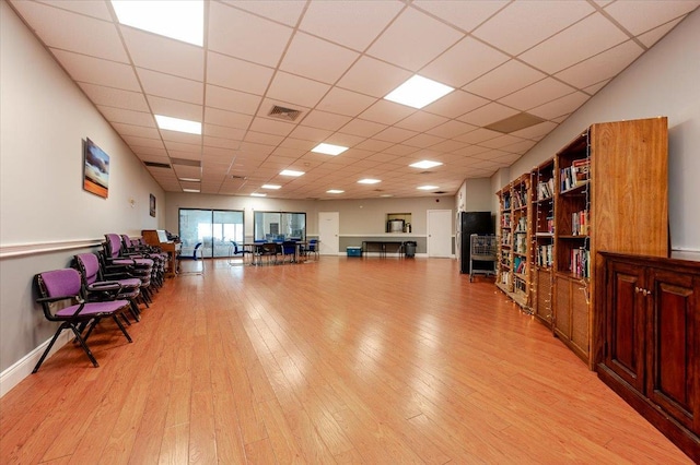 interior space with light wood finished floors, visible vents, and a drop ceiling