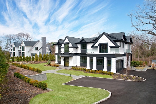 exterior space with an attached garage, a front lawn, and aphalt driveway