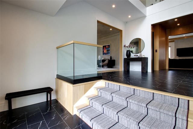 staircase with recessed lighting, marble finish floor, and a towering ceiling