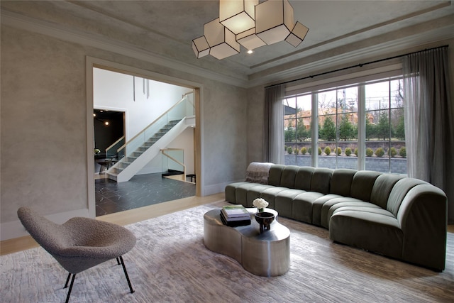 living area with ornamental molding and stairway