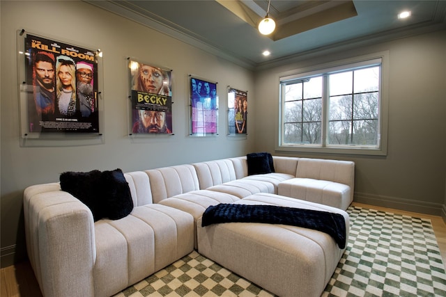 living room featuring crown molding, baseboards, recessed lighting, a raised ceiling, and light wood-style flooring