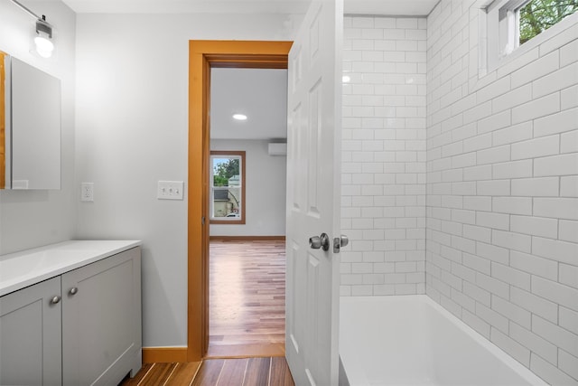 full bathroom featuring plenty of natural light, wood finished floors, vanity, baseboards, and recessed lighting