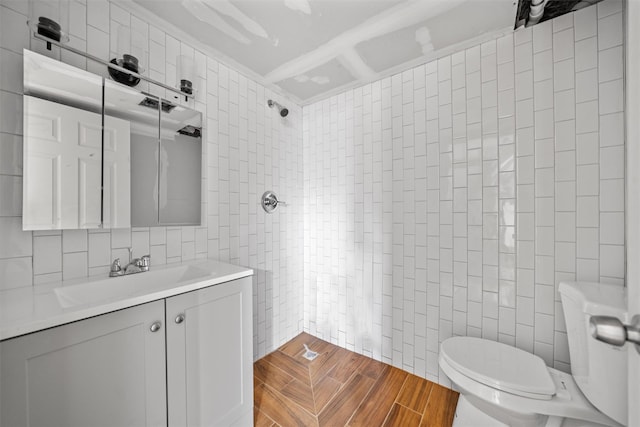 full bathroom with tile walls, toilet, vanity, and a shower