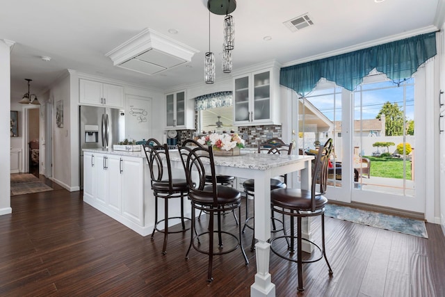 kitchen with glass insert cabinets, stainless steel fridge with ice dispenser, dark wood-type flooring, and visible vents