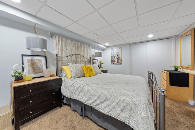 carpeted bedroom with a closet, a drop ceiling, and recessed lighting