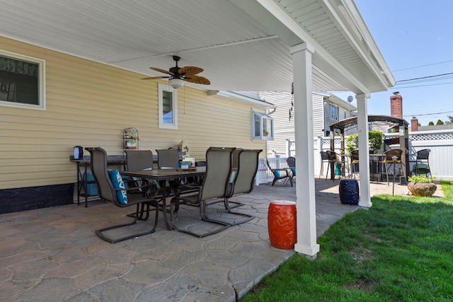 view of patio with ceiling fan, fence, and outdoor dining space