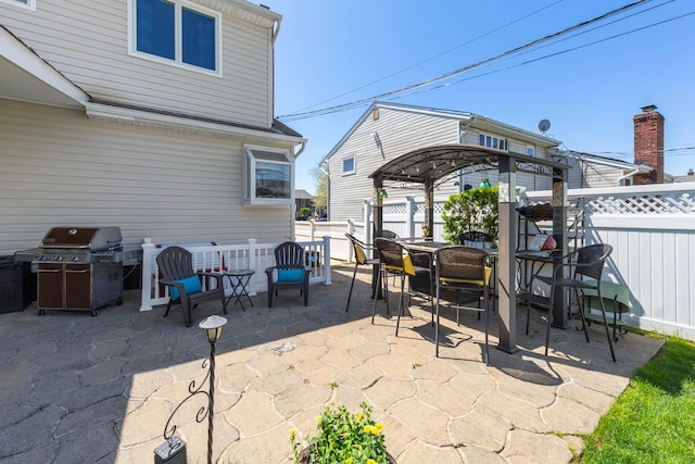 view of patio / terrace with a fenced backyard, outdoor dining space, and a grill