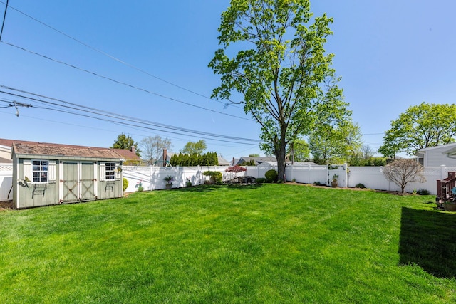 view of yard featuring an outdoor structure, a shed, and a fenced backyard