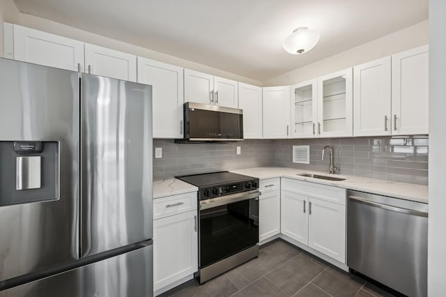 kitchen with appliances with stainless steel finishes, a sink, and white cabinets