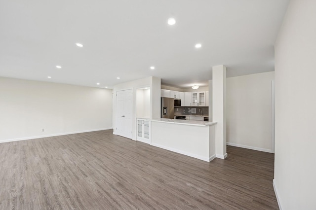 unfurnished living room featuring wood finished floors, baseboards, and recessed lighting
