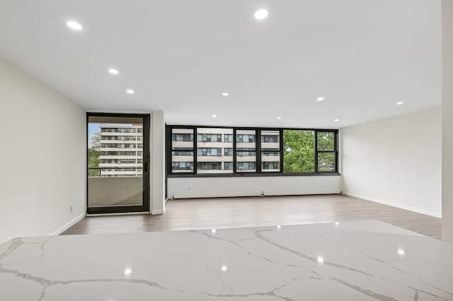 unfurnished room featuring recessed lighting, baseboards, and wood finished floors