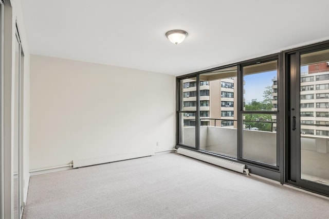 empty room featuring a baseboard heating unit, carpet floors, and floor to ceiling windows