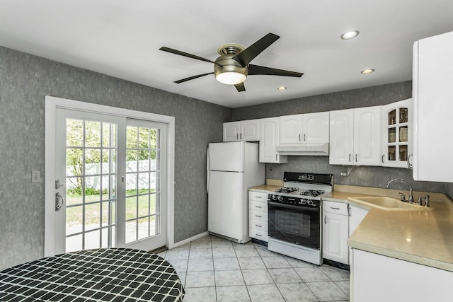 kitchen featuring ceiling fan, a sink, range with gas stovetop, freestanding refrigerator, and under cabinet range hood