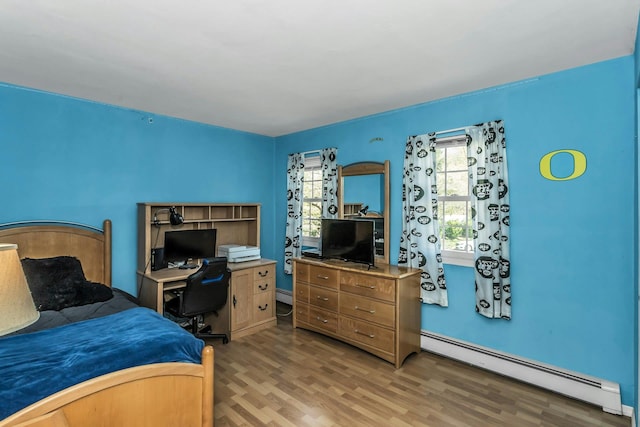 bedroom with light wood-type flooring and a baseboard radiator