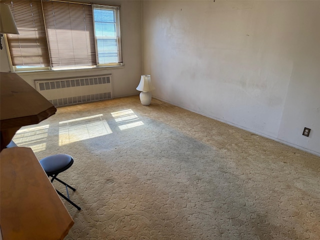 carpeted spare room with radiator heating unit
