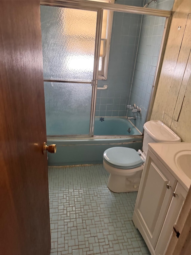 bathroom with vanity, toilet, and shower / bath combination with glass door