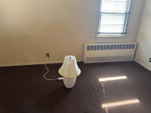carpeted spare room with radiator heating unit and baseboards