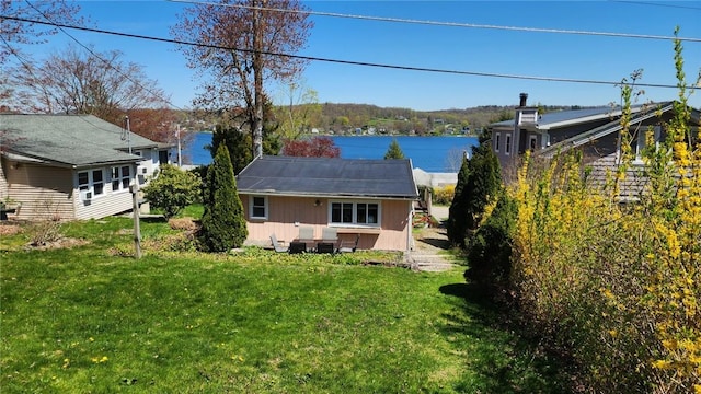 back of house with a yard and an outbuilding