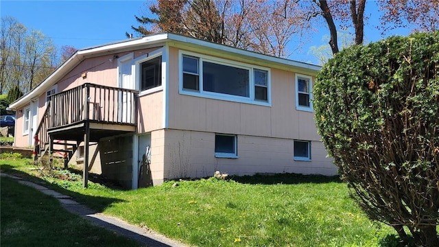 view of property exterior featuring a lawn and a wooden deck