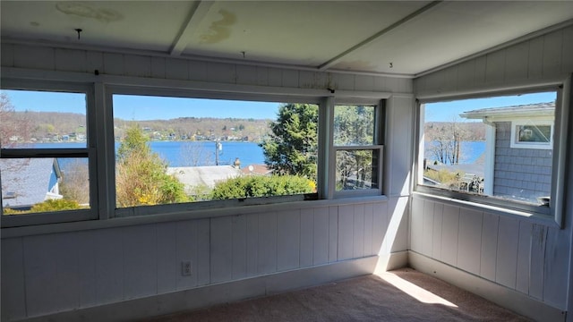 unfurnished sunroom with plenty of natural light and a water view