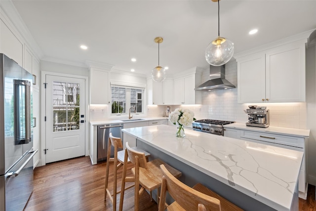 kitchen featuring wall chimney range hood, appliances with stainless steel finishes, tasteful backsplash, and white cabinetry