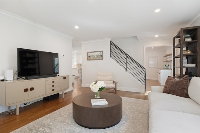 living area with crown molding, recessed lighting, wood finished floors, and stairway