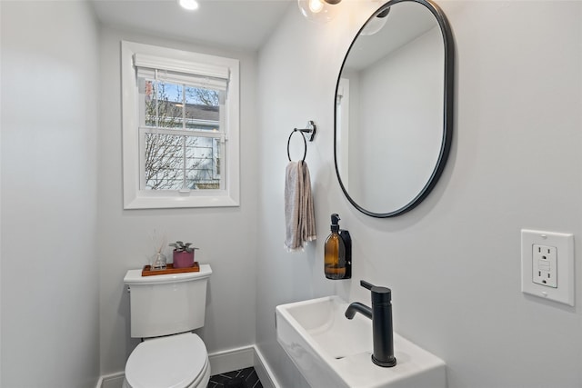 bathroom with baseboards and toilet