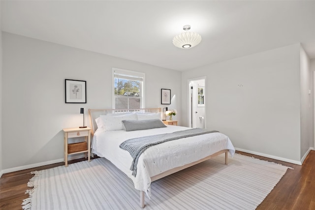 bedroom with baseboards and wood finished floors