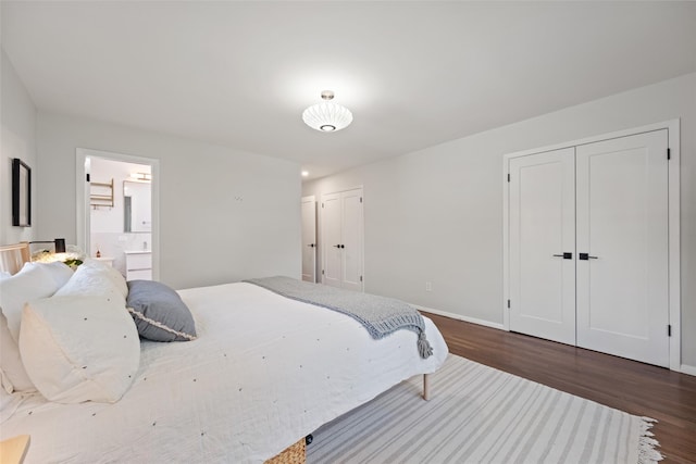 bedroom featuring multiple closets, baseboards, dark wood finished floors, and connected bathroom