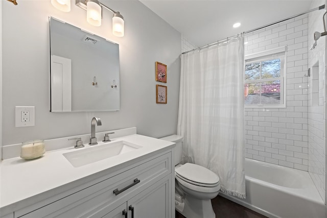 full bathroom with vanity, shower / tub combo with curtain, visible vents, and toilet