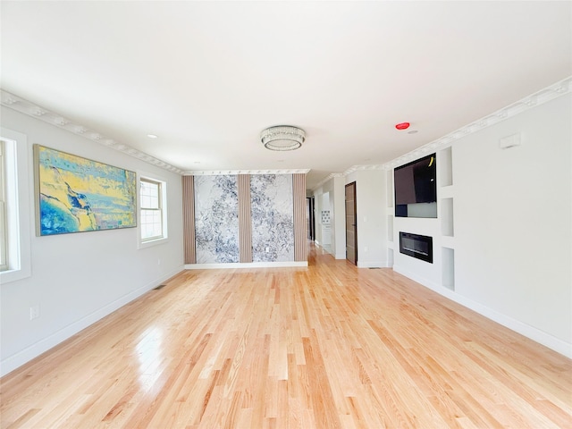 103-22 104th St, Ozone Park, NY 11417 - unfurnished living room with baseboards, a glass covered fireplace, ornamental molding, and light wood-style flooring