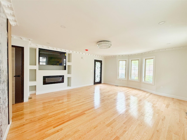 103-22 104th St, Ozone Park, NY 11417 - unfurnished living room with a glass covered fireplace, baseboards, and light wood-type flooring