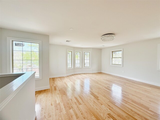 103-22 104th St, Ozone Park, NY 11417 - empty room featuring baseboards, light wood finished floors, and a wealth of natural light