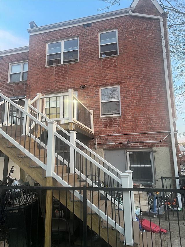 back of property with stairway and brick siding