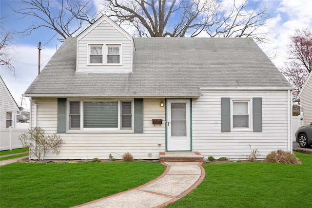 cape cod-style house with fence and a front yard